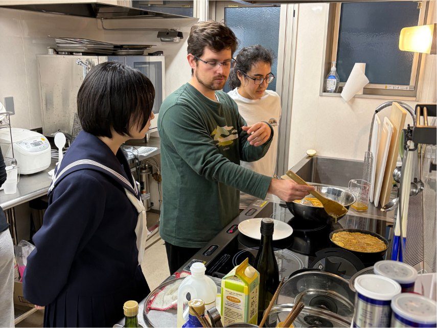 高校生と滞在中のゲストが一緒に厨房に立っている様子